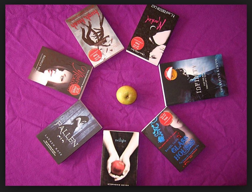  A circle of young adult novels with an apple in the middle on a purple cloth background.